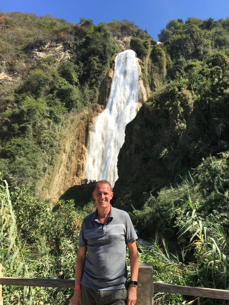 Mark at a bit of a distance in front of the big falls. You can see just to the left of his head the more proximate viewing platform that we were ultimately headed for.