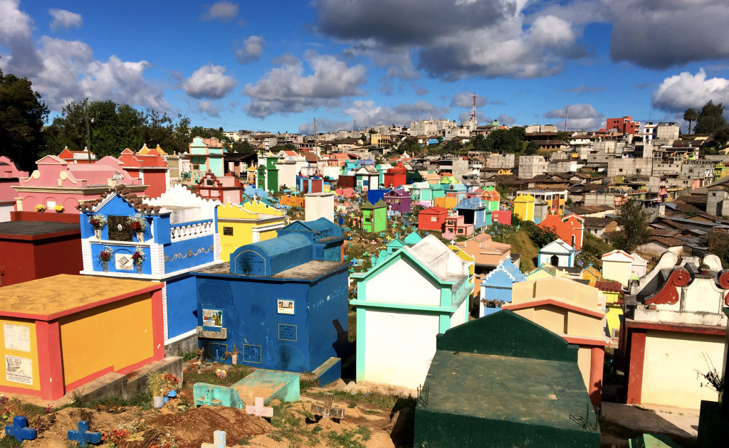 Chichi's brilliant, colorful market is an unexpected counterpoint to the sobriety usually associated with cemeteries. Note how somber the grey buildings of the town are in the background.