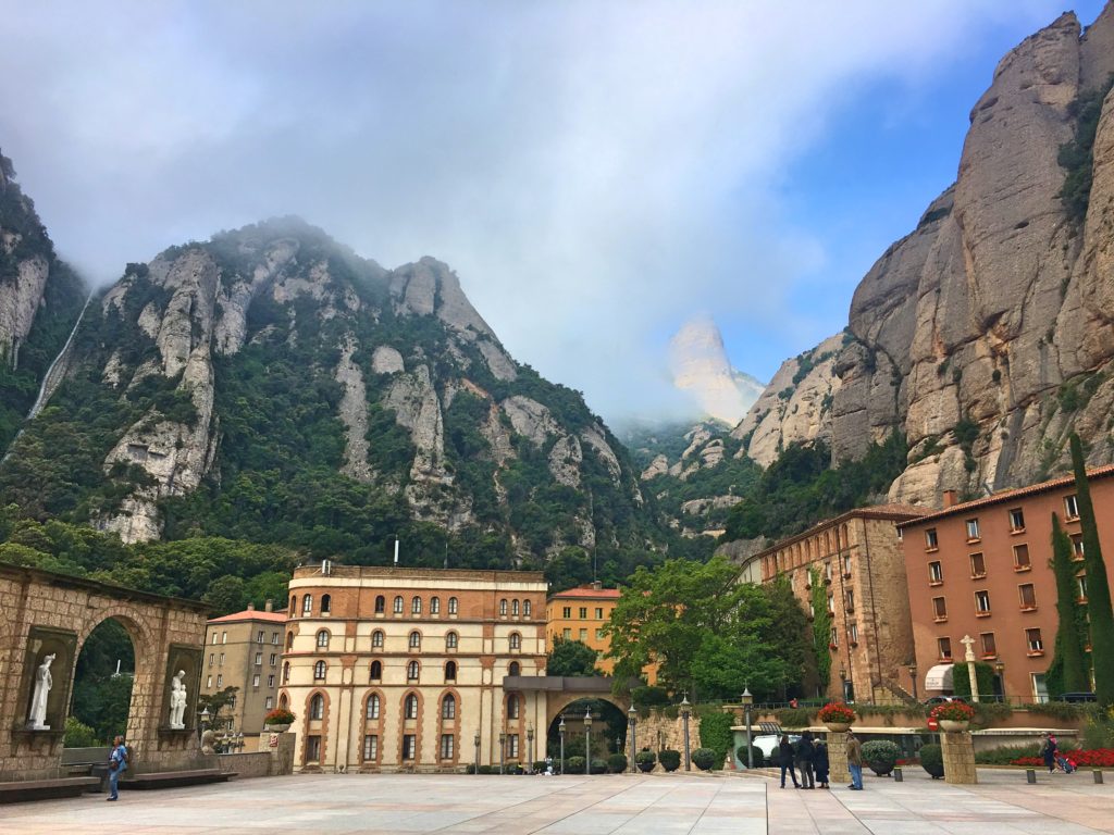 In Catalan "Montserrat" means "saw (or serrated) mountain", with the mountain in the background just one of the "teeth" when seen from a distance